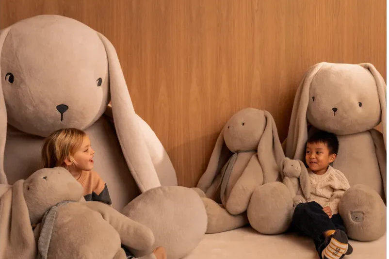 Glückliche Kinder umarmen große Liewood Kuscheltiere - Geschenkideen zum Spielen und Liebhaben