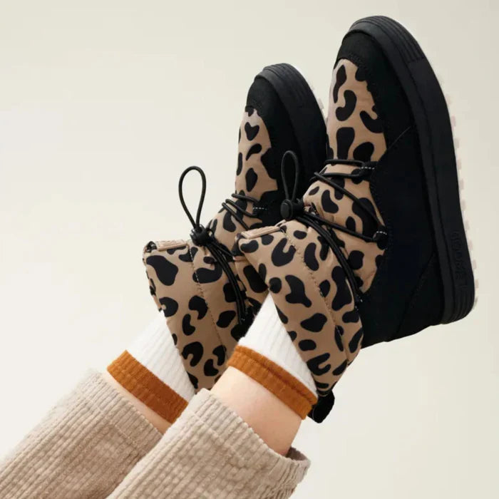 Kinderbeine mit gefütterten Stiefeln im Leopardenmuster – stylische Winterschuhe für Kinder