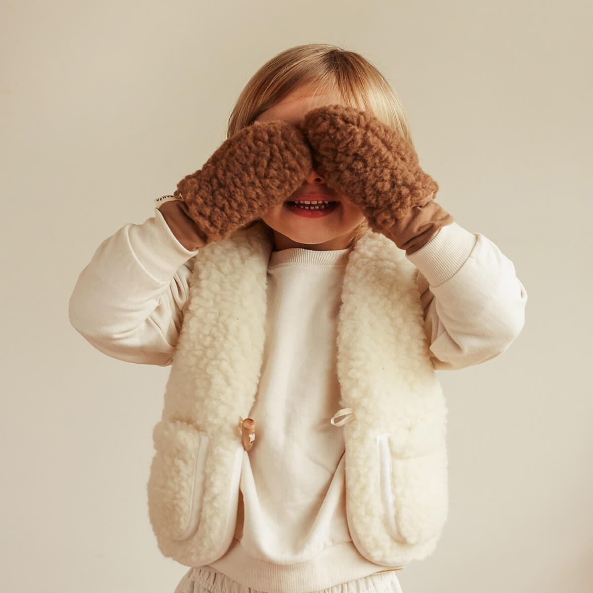 Kleines Kind mit flauschigen Fleece-Handschuhen – Black Week Angebot bei LIBERTYKIDS für warme Kinderhände im Winter