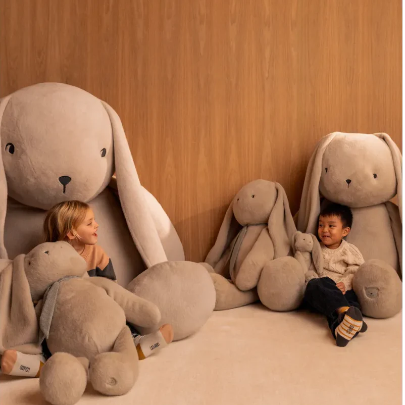 Glückliche Kinder umarmen große Liewood Kuscheltiere - Geschenkideen zum Spielen und Liebhaben
