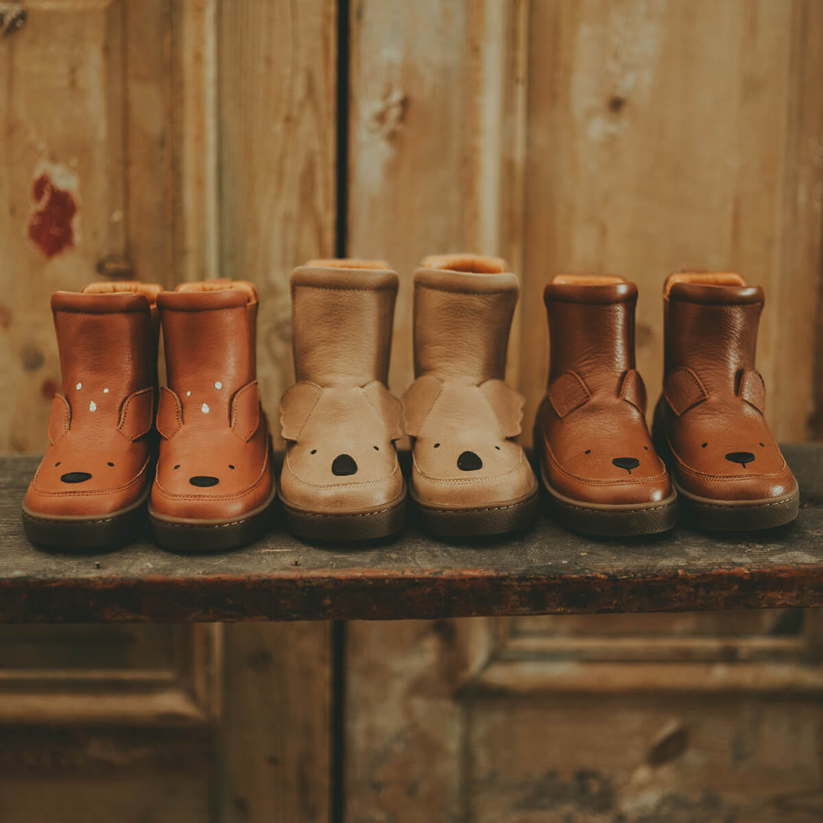 Drei Paar Winterstiefel von Donsje auf einer alten Holzbank